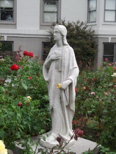 The rose garden is built to surround this statue. Notice the rose in her hand.